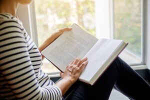 Donna seduta con un libro aperto in mano